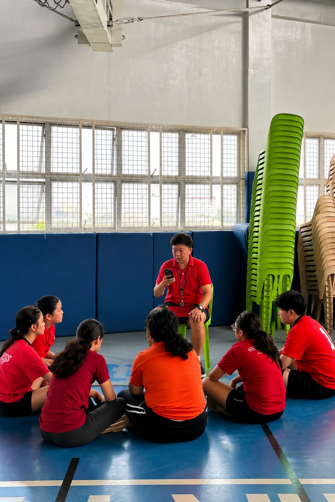 Coach Larmy seated with athletes, talking through the game plan before training